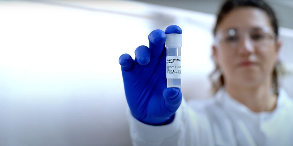 Lab scientist showing a vial of Cultrex Ultimatrix RGF Basement Membrane Extract (BME), or extracellular matrix (ECM)